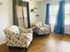 Inviting living room with matching armchairs, curtains, and wood-look floors at 34344 Timberland Blvd, Wesley Chapel, FL 33543