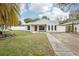 Charming single-Gathering home with a well-maintained lawn, complemented by a vibrant red front door at 3782 Lake St George Dr, Palm Harbor, FL 34684