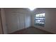 Bedroom featuring neutral carpet, bright window, and closet with louvered doors at 3859 Pheasant Ct, Palm Harbor, FL 34685