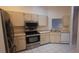 Modern kitchen with stainless steel appliances, neutral cabinets, and tile flooring at 3859 Pheasant Ct, Palm Harbor, FL 34685