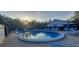 Community pool with lounge chairs and tables on a brick patio offers a relaxing outdoor space at 3859 Pheasant Ct, Palm Harbor, FL 34685