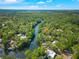 Aerial view of a home nestled among lush greenery along a winding river under a sunny blue sky at 3908 Alafia Blvd, Brandon, FL 33511