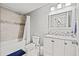 Bathroom featuring a shower/tub combo, white cabinets and a large framed mirror at 3908 Alafia Blvd, Brandon, FL 33511