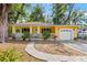 Charming yellow home with a covered porch, stone accents, and a well-manicured lawn at 3908 Alafia Blvd, Brandon, FL 33511