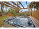 Inviting hot tub under a pergola with string lights, overlooking the tranquil river view and lush greenery at 3908 Alafia Blvd, Brandon, FL 33511