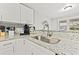 Modern kitchen sink with granite countertops and white cabinets at 3908 Alafia Blvd, Brandon, FL 33511
