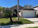 Attractive home exterior with a well-manicured lawn, mature palm trees, and a two-car garage at 4029 Savage Station Cir, New Port Richey, FL 34653