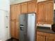 Close-up of a kitchen area with a stainless steel refrigerator and light wooden cabinets offering plenty of storage at 4029 Savage Station Cir, New Port Richey, FL 34653