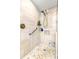 Walk-in shower features a tile floor, tiled walls, a shower head, and a handrail at 4135 Beach Se Dr, St Petersburg, FL 33705
