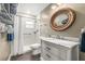 Well-lit bathroom with a decorative mirror, marble countertop, and shower with a grab bar at 4135 Beach Se Dr, St Petersburg, FL 33705