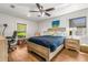 This bedroom features a queen-sized bed with a blue comforter, two windows, and hardwood floors at 4135 Beach Se Dr, St Petersburg, FL 33705