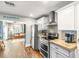 Contemporary kitchen with stainless steel appliances, white cabinets, backsplash, and view into a cozy living area at 4135 Beach Se Dr, St Petersburg, FL 33705