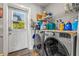 The laundry room has a washer, dryer, storage shelves, and a door to the backyard at 4135 Beach Se Dr, St Petersburg, FL 33705