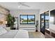 Bright bedroom with water view features wood accent wall, and contemporary furnishings with view to water at 4790 Brittany S Dr # 105, St Petersburg, FL 33715