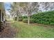Landscaped backyard with lush greenery, privacy hedges, and mature trees at 5088 Championship Cup Ln, Spring Hill, FL 34609