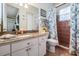 Bathroom with granite vanity, decorative mirror, floral shower curtain, and tiled shower at 5088 Championship Cup Ln, Spring Hill, FL 34609