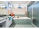 Bright bathroom featuring soaking tub, glass shower, tiled accents, and ample natural light at 5088 Championship Cup Ln, Spring Hill, FL 34609