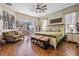 Comfortable main bedroom with decorative ceiling fan, sitting area, and sliding glass doors to lanai at 5088 Championship Cup Ln, Spring Hill, FL 34609