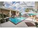 Inviting screened-in pool area complete with hot tub, a vibrant beach mural, and tropical accents at 5088 Championship Cup Ln, Spring Hill, FL 34609