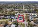 Aerial view of a blue two-story home with street view and neighborhood in the distance with a red home boundary at 5526 14Th S Ave, Gulfport, FL 33707