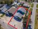 Aerial view of a blue two-story home with manicured landscaping and a red home boundary at 5526 14Th S Ave, Gulfport, FL 33707