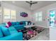 Beautiful living room featuring a turquoise sectional, decorative mirror, large windows, and stylish décor at 5526 14Th S Ave, Gulfport, FL 33707