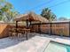 Outdoor tiki bar area with custom wood bar and barstools next to the pool at 5526 14Th S Ave, Gulfport, FL 33707