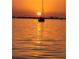 Silhouette of sailboat sailing into the sunset over a calm ocean at 5526 14Th S Ave, Gulfport, FL 33707