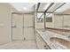 Bathroom featuring double sinks with a mirror, walk-in shower with sliding doors at 7435 Woodhollow Rd, Spring Hill, FL 34606