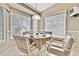 Cozy breakfast nook bathed in natural light from surrounding windows and a quaint chandelier at 7435 Woodhollow Rd, Spring Hill, FL 34606