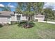 Well-maintained front yard with lush green lawn and mature shade trees at 7435 Woodhollow Rd, Spring Hill, FL 34606
