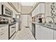 Well-lit kitchen featuring white cabinetry, stainless steel appliances, and granite countertops at 7435 Woodhollow Rd, Spring Hill, FL 34606