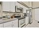 Spacious kitchen featuring white cabinets, stainless steel appliances, and granite countertops at 7435 Woodhollow Rd, Spring Hill, FL 34606