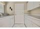 This laundry room features a utility sink and a washer and dryer set with white cabinets at 7435 Woodhollow Rd, Spring Hill, FL 34606