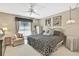 Cozy main bedroom features a ceiling fan, natural light, and a black and white color scheme at 7435 Woodhollow Rd, Spring Hill, FL 34606