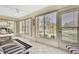 Bright sunroom with tile flooring and several windows providing ample natural light and views of the yard at 7435 Woodhollow Rd, Spring Hill, FL 34606
