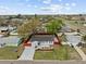 Charming single-story home featuring a new driveway, manicured landscaping, and a vibrant red perimeter fence at 7480 Hobson Ne St, St Petersburg, FL 33702