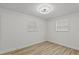Neutral bedroom with two windows with blinds and wood-look flooring at 7480 Hobson Ne St, St Petersburg, FL 33702