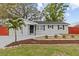 Charming single-story home featuring a gray exterior, well-manicured lawn, and a delightful palm tree in the front yard at 7480 Hobson Ne St, St Petersburg, FL 33702