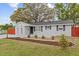 Charming single-story home featuring a gray exterior, well-manicured lawn, and mature shade trees in the front yard at 7480 Hobson Ne St, St Petersburg, FL 33702