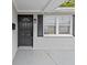 The home's exterior features a black front door, black shutters, and a window at 7480 Hobson Ne St, St Petersburg, FL 33702