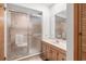 Bathroom featuring a glass shower, light wood cabinets, and large mirror at 7703 Rockville Ct # 0, New Port Richey, FL 34654