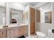 Bathroom with a vanity, mirror, toilet, and walk-in shower with wood style doors at 7703 Rockville Ct # 0, New Port Richey, FL 34654