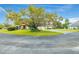 Residential street scene with mature trees, lawn, and residential property at 7703 Rockville Ct # 0, New Port Richey, FL 34654