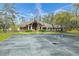 Exterior view of the community clubhouse, parking area, landscaping, and American flag at 7703 Rockville Ct # 0, New Port Richey, FL 34654
