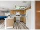 Cozy kitchen featuring wood cabinets, white appliances, a skylight, and a breakfast bar area at 7703 Rockville Ct # 0, New Port Richey, FL 34654