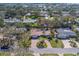 Aerial view of a charming home with lush landscaping, brick driveway, and tile roof in a desirable neighborhood at 809 Royal Dr, Largo, FL 33770