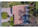 Overhead shot of the home with a tile roof, lush landscaping, and a circular driveway at 809 Royal Dr, Largo, FL 33770
