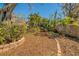 Lush backyard featuring mature trees, mulch beds, and manicured landscaping, creating a serene and private outdoor space at 809 Royal Dr, Largo, FL 33770