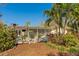 Spacious backyard with a patio, tropical foliage, and lush landscaping, perfect for outdoor entertaining and relaxation at 809 Royal Dr, Largo, FL 33770